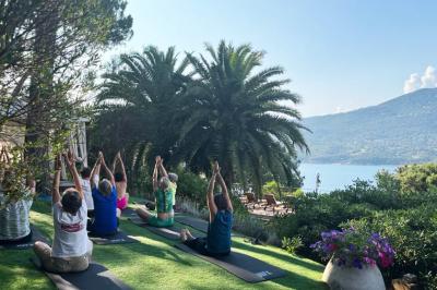 Salon lumineux avec canapé blanc, table basse, bureau près de la fenêtre et vue sur un jardin verdoyant.