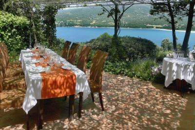 Salon lumineux avec canapé blanc, table basse, bureau près de la fenêtre et vue sur un jardin verdoyant.