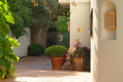 Salon lumineux avec canapé blanc, table basse, bureau près de la fenêtre et vue sur un jardin verdoyant.