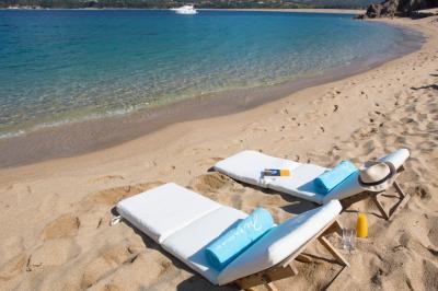 Salon lumineux avec canapé blanc, table basse, bureau près de la fenêtre et vue sur un jardin verdoyant.