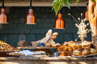 Salon lumineux avec canapé blanc, table basse, bureau près de la fenêtre et vue sur un jardin verdoyant.