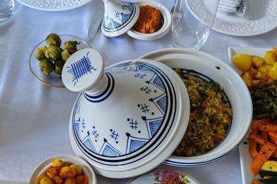 Plat de viande rôtie décorée de brochettes de légumes et servi avec des accompagnements variés sur une table dressée.