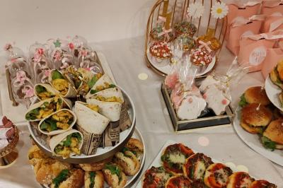 Plat de viande rôtie décorée de brochettes de légumes et servi avec des accompagnements variés sur une table dressée.