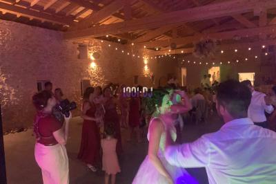 Un DJ mixant de la musique sur une table de mixage dans une salle éclairée par des lumières violettes.