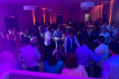 Miniature DJ Biganos (Gironde) - Deejayniko G #14 Un DJ mixant de la musique sur une table de mixage dans une salle éclairée par des lumières violettes.