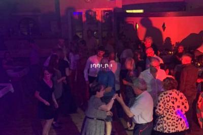 Miniature DJ Biganos (Gironde) - Deejayniko G #15 Un DJ mixant de la musique sur une table de mixage dans une salle éclairée par des lumières violettes.