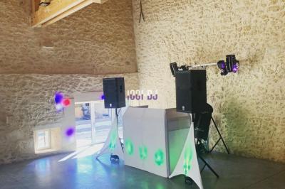 Miniature DJ Biganos (Gironde) - Deejayniko G #19 Un DJ mixant de la musique sur une table de mixage dans une salle éclairée par des lumières violettes.