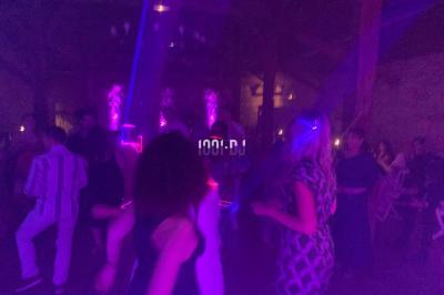 Miniature DJ Biganos (Gironde) - Deejayniko G #25 Un DJ mixant de la musique sur une table de mixage dans une salle éclairée par des lumières violettes.