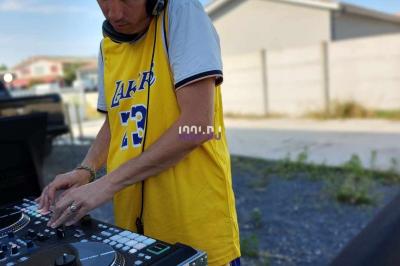 Miniature DJ Biganos (Gironde) - Deejayniko G #32 Un DJ mixant de la musique sur une table de mixage dans une salle éclairée par des lumières violettes.