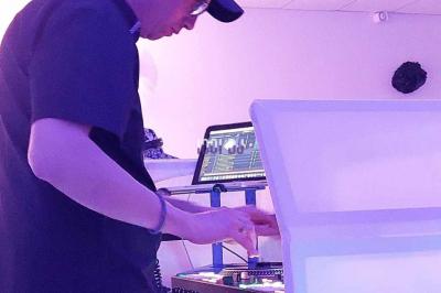 Miniature DJ Biganos (Gironde) - Deejayniko G #34 Un DJ mixant de la musique sur une table de mixage dans une salle éclairée par des lumières violettes.