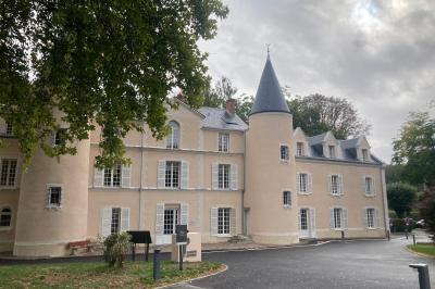 Rivière calme bordée d'arbres hauts et verdoyants, reflétant la lumière du soleil dans un environnement paisible.