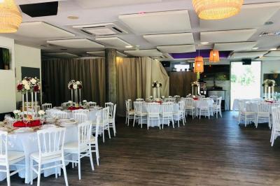 Étang entouré de végétation avec des montagnes en arrière-plan sous un ciel bleu parsemé de nuages.