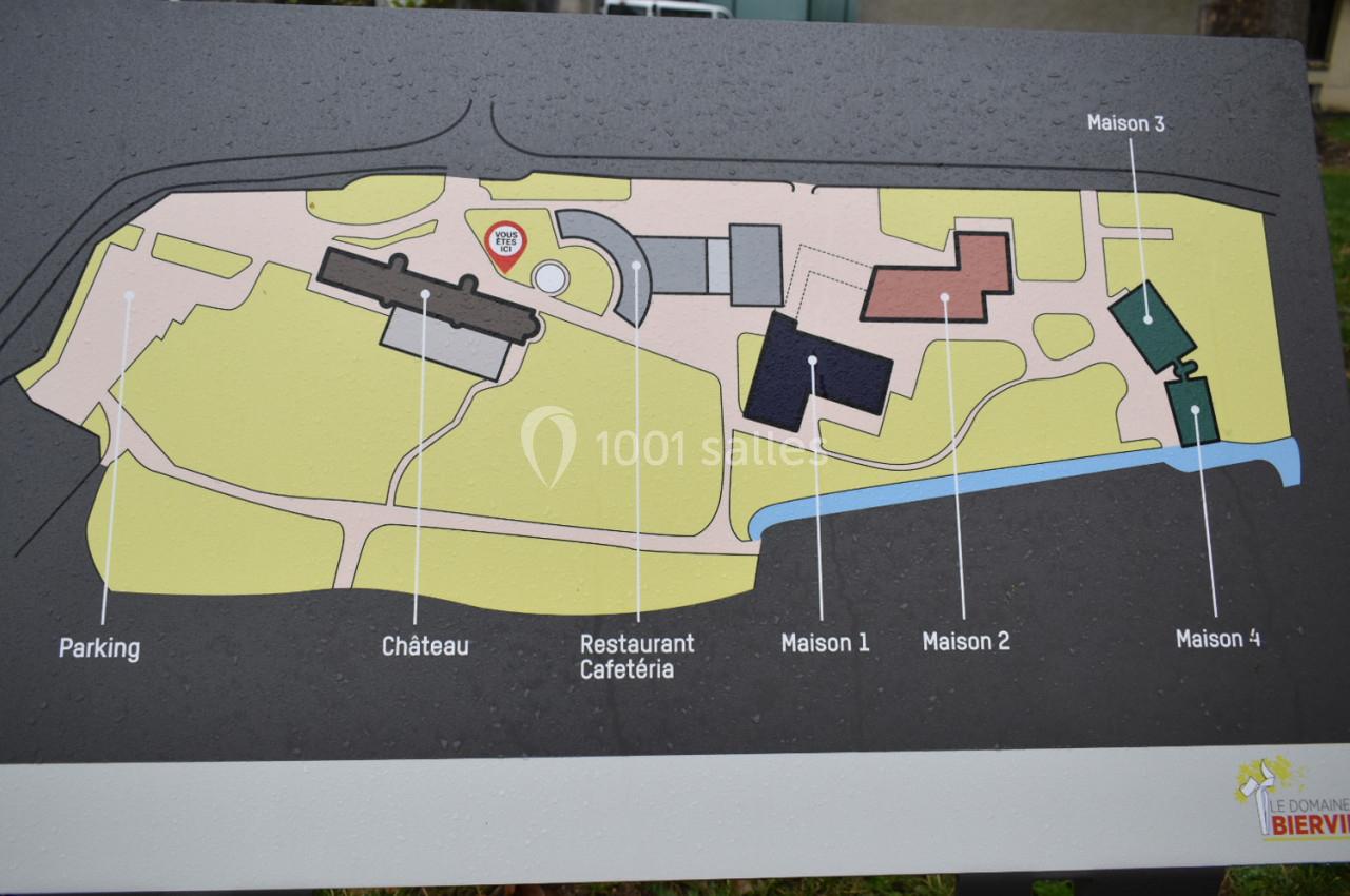 Plan illustré d'un domaine avec indications des bâtiments principaux : château, restaurant, maisons et parking.