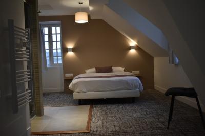 Bâtiment circulaire en pierre avec une pelouse et des arbres, sous un ciel partiellement nuageux.