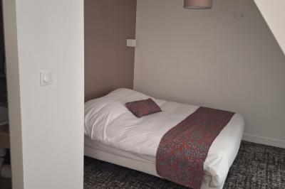 Bâtiment circulaire en pierre avec une pelouse et des arbres, sous un ciel partiellement nuageux.