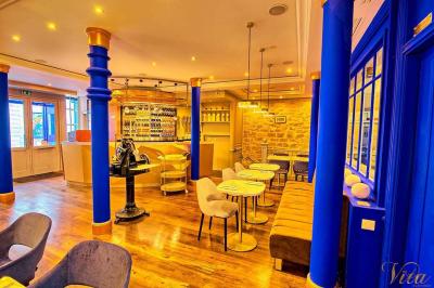 Verre de cognac, bouteille en arrière-plan, cigare allumé posé sur un cendrier et briquet sur une table en marbre.