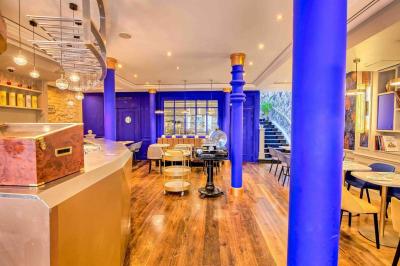 Verre de cognac, bouteille en arrière-plan, cigare allumé posé sur un cendrier et briquet sur une table en marbre.