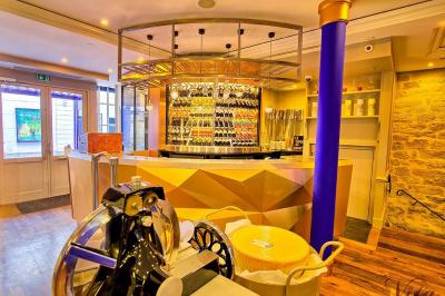 Verre de cognac, bouteille en arrière-plan, cigare allumé posé sur un cendrier et briquet sur une table en marbre.