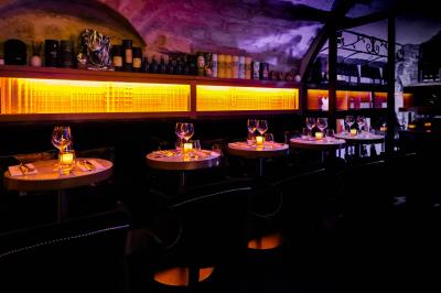 Verre de cognac, bouteille en arrière-plan, cigare allumé posé sur un cendrier et briquet sur une table en marbre.