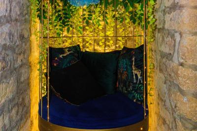 Verre de cognac, bouteille en arrière-plan, cigare allumé posé sur un cendrier et briquet sur une table en marbre.