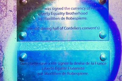 Verre de cognac, bouteille en arrière-plan, cigare allumé posé sur un cendrier et briquet sur une table en marbre.