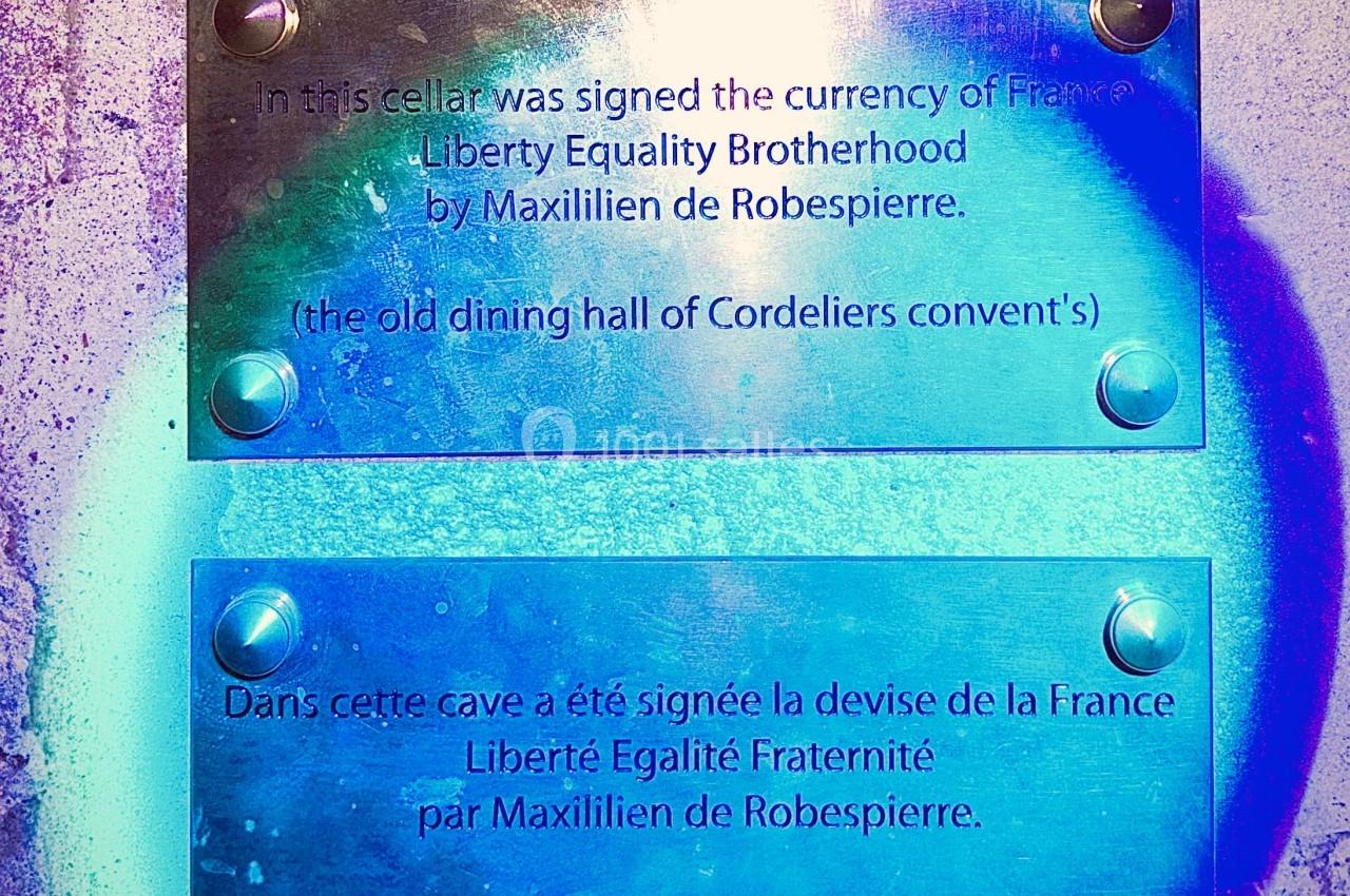 Plaques commémoratives en anglais et français sur un mur, mentionnant la devise de la France signée par Robespierre.