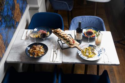 Verre de cognac, bouteille en arrière-plan, cigare allumé posé sur un cendrier et briquet sur une table en marbre.