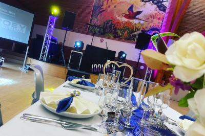 Miniature DJ Lantic (Côtes-d'Armor) - Dj Daroey #3 Salle en pierre avec éclairage coloré, scène équipée de projecteurs et écran en fond, ambiance festive.