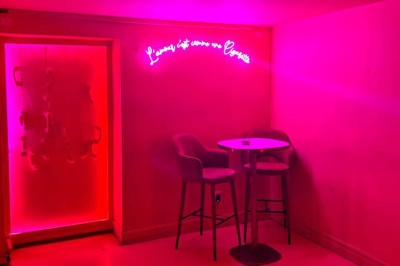 Salle avec bar, banquettes rouges, décor rétro, disques vinyles au mur et éclairage chaleureux.