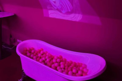 Salle avec bar, banquettes rouges, décor rétro, disques vinyles au mur et éclairage chaleureux.