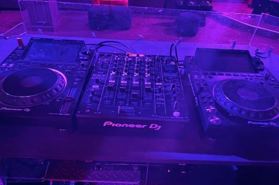 Salle avec bar, banquettes rouges, décor rétro, disques vinyles au mur et éclairage chaleureux.