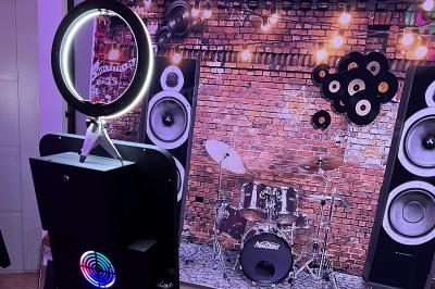 Salle décorée pour un mariage avec des tables dressées, des ballons rouges et des lettres lumineuses formant ’LOVE’.