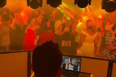 Salle de réception en pierre avec plafond en bois, tables rondes dressées et éclairage chaleureux.