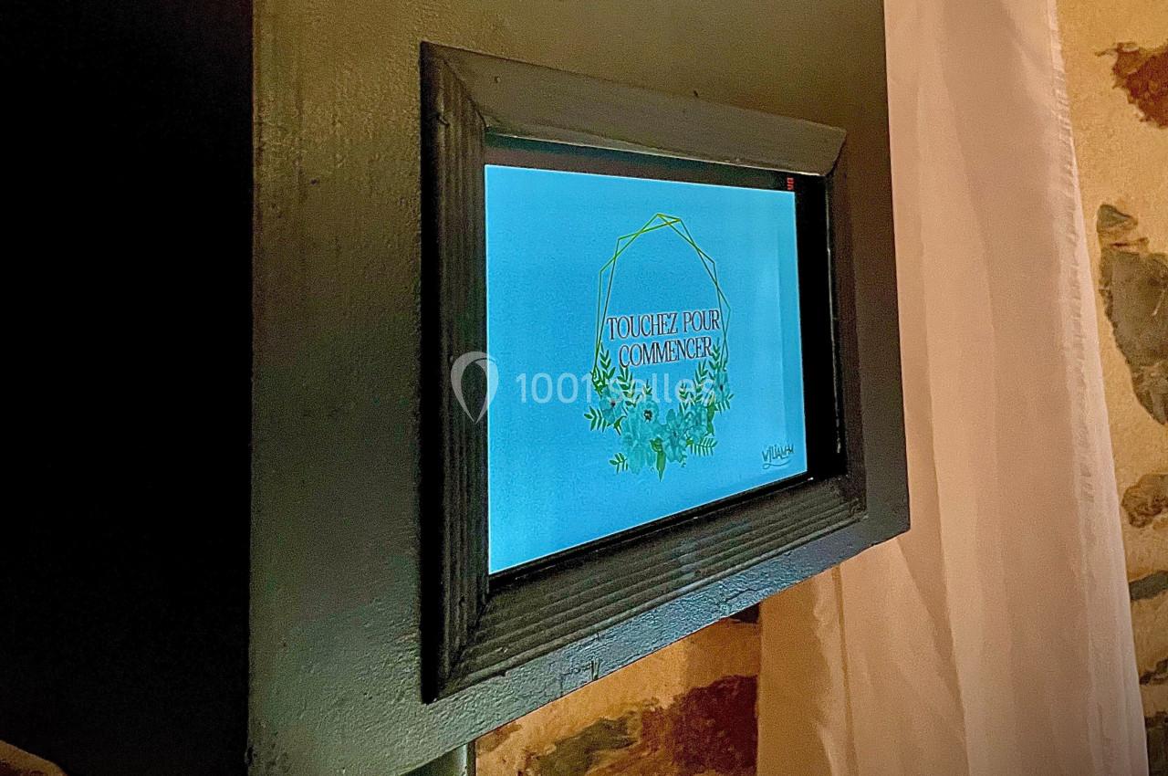 Écran tactile encastré affichant un message ’Touchez pour commencer’ avec un design floral sur fond bleu.