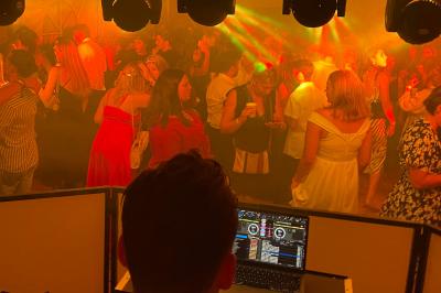 Salle de réception en pierre avec plafond en bois, tables rondes dressées et éclairage chaleureux.