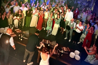 Un groupe de personnes rassemblées dans une salle de réception, applaudissant près d'une table garnie de desserts.