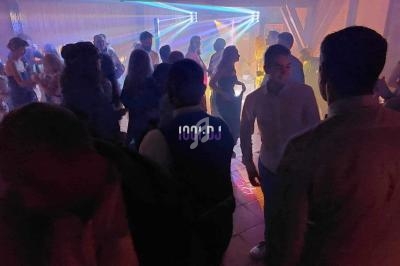 Groupe de personnes dansant dans une salle sombre avec des jeux de lumière colorés.