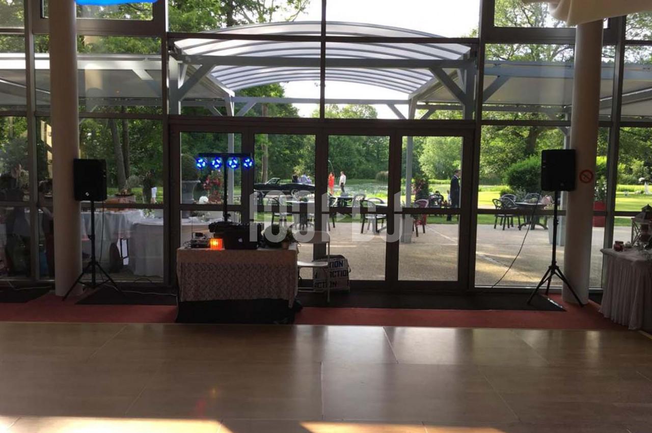 Salle lumineuse avec baie vitrée donnant sur un jardin, équipée d'une table de mixage et de haut-parleurs.