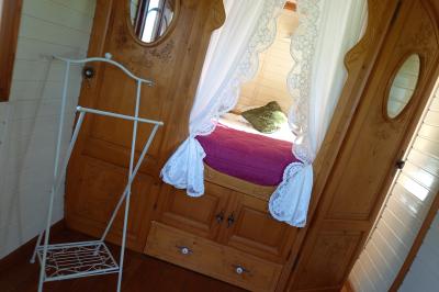 Voiture ancienne rouge décorée de fleurs blanches et feuillages, stationnée devant un bâtiment à colombages.