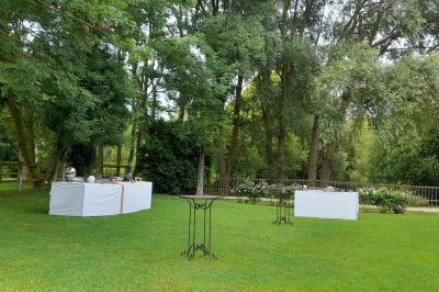 Voiture ancienne rouge décorée de fleurs blanches et feuillages, stationnée devant un bâtiment à colombages.