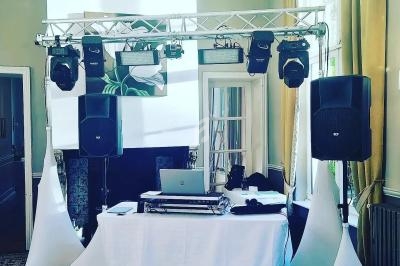 Installation de matériel de sonorisation et d'éclairage avec une table de mixage dans une salle lumineuse.