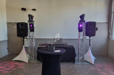 Installation de matériel de sonorisation et d'éclairage avec une table de mixage dans une salle lumineuse.