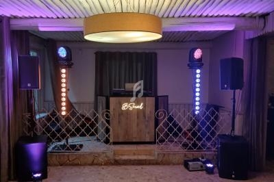 Installation de matériel de sonorisation et éclairage coloré sur une scène avec une table de mixage en arrière-plan.