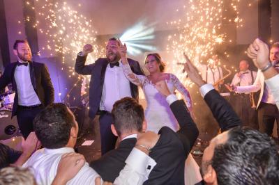 Groupe de personnes souriantes posant ensemble lors d'un événement festif en plein air, portant des t-shirts assortis.