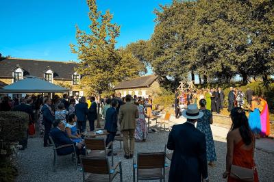 Personnes dansant sous des lumières colorées dans une salle sombre avec une scène équipée de matériel de DJ.