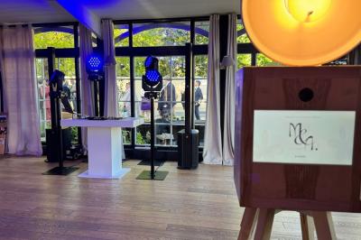 Personnes dansant sous des lumières colorées dans une salle sombre avec une scène équipée de matériel de DJ.