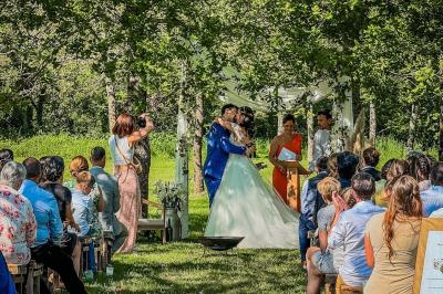 Personnes dansant sous des lumières colorées dans une salle sombre avec une scène équipée de matériel de DJ.