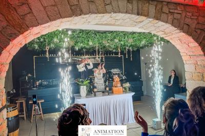 Personnes dansant sous des lumières colorées dans une salle sombre avec une scène équipée de matériel de DJ.