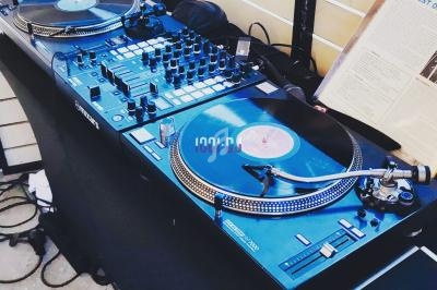 Deux platines vinyles et une table de mixage installées sur un meuble, prêtes pour une session DJ.