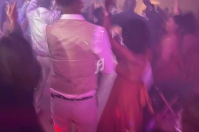 Groupe de personnes dansant dans une ambiance festive avec éclairage tamisé et fumée.